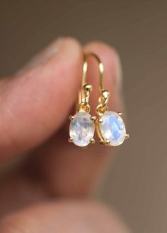 Our Moonstone Dangle Earrings in 18k gold vermeil are just the right size to be noticed and small enough to wear all day comfortably. The stone is a large 7mm x 5mm natural blue flash genuine oval Moonstone, set in a sturdy prong setting. A classic with a touch of modern, also available in sterling silver. Sold as a pair, comes with extra silicone ear backs to keep them secure.DETAILS• Dimensions: Stone - 7mm x 5mm, total length - 22mm• Weight - 0.7 g• Material - 925 sterling silver, 18k thick g Dainty Gemstone Dangle Earrings, Hypoallergenic Gold Moonstone Jewelry, Minimalist Moonstone Earrings For Anniversary, Delicate 14k Gold Gemstone Earrings, Dainty 14k Gold Gemstone Earrings, Minimalist Moonstone Jewelry With Ear Wire, Dainty Moonstone Earrings For Gift, Minimalist 14k Gold Earrings With Gemstone, Delicate Hypoallergenic Moonstone Jewelry