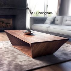 a wooden table sitting on top of a carpeted floor next to a white couch