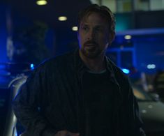 a man standing in front of a car at night