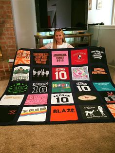 a woman sitting on the floor with a blanket made out of t - shirts