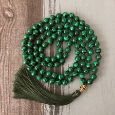 This Malachite Beaded Japa Mala Necklace is a traditional prayer necklace made from beautiful green Malachite beads. It is believed that using a Japa Mala during meditation and prayer can help calm the mind and deepen spiritual awareness. The benefits of using a Japa Mala include promoting mindfulness, increasing focus, and helping to connect with a higher power. The Malachite stone is known for its healing properties and is believed to protect the wearer from negative energies while promoting e Spiritual Malachite Necklace For Healing, Traditional Jade Necklaces For Meditation, Traditional Jade Necklace For Meditation, Spiritual Jade Beads For Meditation, Green Spiritual Beads For Healing, Traditional Green Necklace For Meditation, Green Spiritual Beads, 108 Count, Green Hand-strung Spiritual Mala, Traditional Green Jade Beaded Necklaces