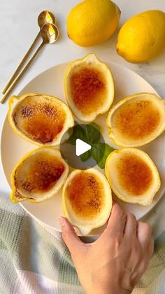 a person holding a plate with deviled eggs on it and lemons in the background