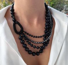 a woman wearing a necklace with black beads