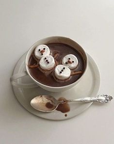 a cup of hot chocolate with marshmallows in the shape of snowmen