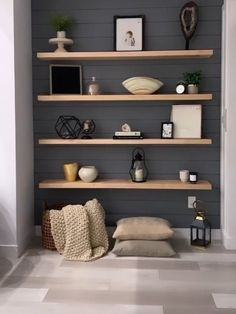 a living room with shelves and pillows on the floor, some bookshelves in front of them