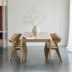 a table with chairs and a vase on it