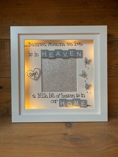 a white frame with some words in it on a wooden table next to a wall