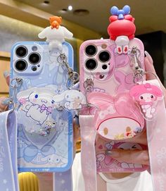 two cell phones with hello kitty cases attached to them