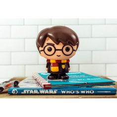 a star wars figurine is sitting on top of some books and other items