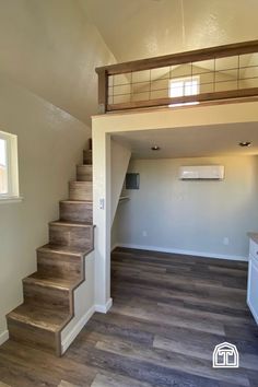 an empty living room with stairs leading up to the second floor