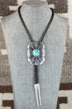 This turquoise and sterling silver bolo tie was made by Navajo silversmith Rosita Singer. The back is signed T&R Singer and stamped sterling.Tie Length: 22"Length: 2 3/8"Width: 1 3/4"Tips:Length: 2 1/8"Width: 1/4"Free shipping on all orders! We ship with USPS and always include tracking. All orders ship within a day of payment.Returns are accepted up to 30 days after you receive your order. Just send us a message. Our shop offers cash back or store credit. The item must be returned in new condit Southwestern Sterling Silver Bolo Tie As Gift, Western Lariat Jewelry As Gift, Western Style Lariat Jewelry As Gift, Western Style Lariat Jewelry For Gifts, Southwestern Bolo Tie With Sliding Knot, Southwestern Lariat Turquoise Necklace, Southwestern Adjustable Lariat Turquoise Necklace, Southwestern Adjustable Turquoise Lariat Necklace, Adjustable Southwestern Turquoise Lariat Necklace