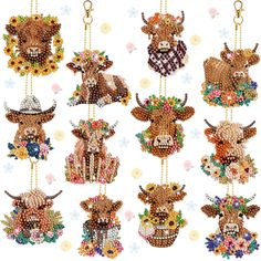 a bunch of beaded cows hanging from strings with flowers on the bottom and one cow wearing a cowboy hat