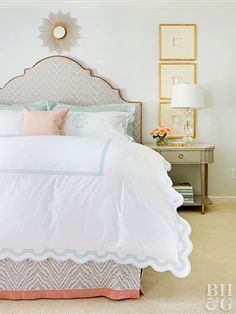 a bed with white sheets and pillows in a bedroom