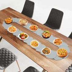 a wooden table topped with lots of plates filled with different types of food on top of it