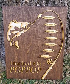 a wooden sign that says hooked on popop with a fish and fishing rod attached to it