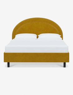 a bed with a yellow headboard and white sheets