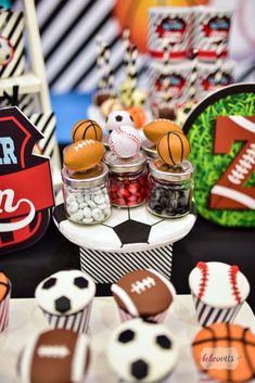 sports themed desserts are displayed on a table with cupcakes and candies