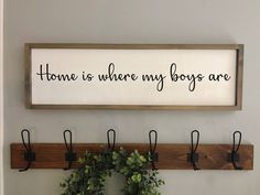 there is a sign that says home is where my boys are hanging on the wall