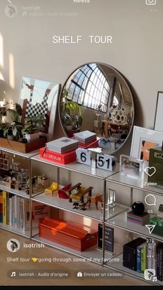 an image of a shelf with books and other items on it in front of a round mirror