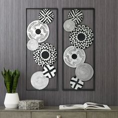 two black and white art pieces hanging on the wall above a dresser in a living room