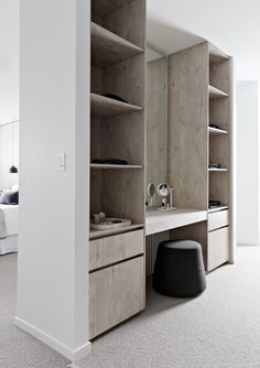 a bedroom with white walls and open shelving