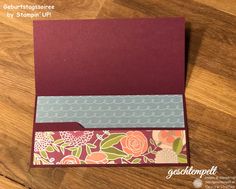 a close up of a folded card on a wooden table with wood grain flooring