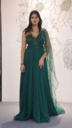 A mix of royal and modern, this long dress in Sea Green colour handcrafted on georgette with multicolour crystal and stripes has an entirely different look because of the jacket. Style this for the classic indo western look.Fabric- georgette with net, work- metal stripes with multicolor crystalOccasion: Wedding ,Cocktail, Family & Pooja,Reception ,EngagementNo. Of Components: 1 Style: Gown Fabric: Georgette Work: Sequin, Cut dana Colour: Sea Green Chest: 36 Note:- Originally Stitched in 36 but c Anarkali Gown With Cape Sleeves For Evening, Festive Evening Dress With Cape Sleeves For Reception, Embellished Anarkali Dress With Cape Sleeves, Anarkali Dresses With Embellished Cape Sleeves, Anarkali Dress With Cape Sleeves And Sequins, Sleeveless Party Dress With Dupatta, Embellished Green Anarkali Set For Party, Green Embellished Anarkali Set For Party, Party Wear Sleeveless Dress With Sheer Dupatta