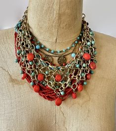 "This is an instant collection of necklaces with a bohemian style in red and turquoise.  Wear them together or on their own to create different looks. The necklaces are a combination of glass, metals, materials, textures and finishes for an amazing assortment!  (1)  Fabulous gold tone metal, chain bib necklace. The metal links have a textured finish.  Slices of red coral and dyed turquoise howlite beads dangle and move.  Great condition.  19\" - 22\" long inside neckline measurement. (2) Vintage multi strand deep red glass seed bead necklace.  14 strand end with silver toned round bead and a J clasp.  Great condition.  21\" long (3) Woven strand of robins egg blue seed beads. Closes with a button.  20\" long (4) Multi beaded strand with darkened metal in red and turquoise blue glass.  Roun Bohemian Bib Necklace With Round Beaded Chain, Bohemian Bib Necklace With Round Beads, Bohemian Bib Necklace With Beaded Chain, Bohemian Turquoise Bib Necklace With Colorful Beads, Bohemian Red Necklaces For The Beach, Red Bohemian Necklace For Beach, Bohemian Red Necklace For Beach, Bohemian Beaded Multi-strand Bib Necklaces, Bohemian Multi-strand Beaded Bib Necklaces