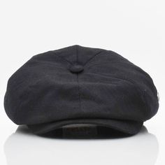 a black hat is sitting on a white surface