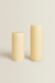 two white candles sitting next to each other