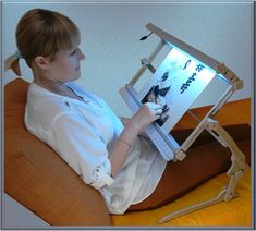 a woman sitting in a chair with an easel