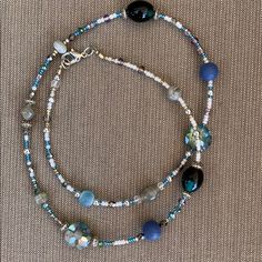 Handmade By Me; Bead Necklace In Blue, Silver, White And Gray Beads. Two Larger Green/Black Stones. Necklace Is Accented With Silver Pieces. Necklace Is 23” Long. Would Look Beautiful Layered With A Smaller Necklace. One Of A Kind. Blue Crystal Necklaces With Round Glass Beads, Blue Round Beaded Glass Crystal Necklace, Blue Glass Crystal Necklace With Round Beads, Blue Single Strand Long Beaded Necklace, Blue Long Single Strand Beaded Necklace, Blue Beaded Long Necklace With Round Beads, Silver Necklace With Czech Glass Spacer Beads, Blue Czech Glass Beaded Chain, Blue Long Necklace With Colorful Round Beads