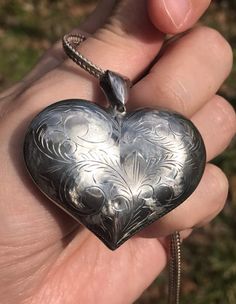 We are utterly charmed by this Vintage Sterling Silver Engraved Heart pendant. It has presence, elegance, and such lovely energy. What more dear present than a talisman that says "You have my heart" - and given the upcoming Mother's Day holiday, "Thank you for taking such tender care of mine." Rare for its' size and width, made in the 1980s. Chain not included in the listing, but included in the photographs so that you see the pendant closer to how it will look when a chain is added later to be Antique Silver Engraved Heart Pendant Jewelry, Vintage Antique Silver Heart Pendant Jewelry, Antique Heart-shaped Engraved Necklace, Silver Heart-shaped Etched Necklace, Tender Care, Antique Heart-shaped Necklace For Memorial, Vintage Sterling Silver, Heart Pendant, Mothers Day