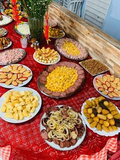 a table topped with lots of different types of food on plates next to each other