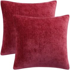 two red velvet pillows sitting next to each other