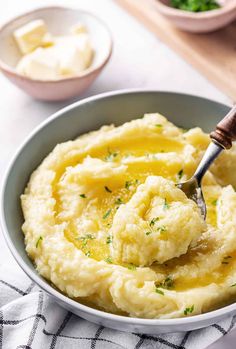 mashed potatoes in a bowl with butter and parsley on the side, ready to be eaten