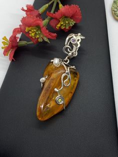 "ARTISAN AMBER GEMSTONE PENDANT Hand-made Sterling Silver. Stones used: Baltic Amber, Pearls, Peridot, Amethyst. Height - 73mm, Width - 30mm. Unique Handcrafted One-of a-kind Design Pendant Each Piece of Jewelry in my Collection is Absolutely One of a Kind! When you start wearing a piece of my jewelry you will fall in love with it more and more each day and feel that good Energy and Love that I pass into it while creating this piece of Art. A piece of Art created for you to be inspired and love Elegant Gemstone Pendant Beads, Elegant Gemstone Pendant, Unique Cabochon Necklaces For Wedding, Elegant Round Amber Beads And Cabochons, Fusion Style Pearl Pendant Jewelry As Gift, Fusion Style Pearl Pendant Jewelry For Gift, Elegant Amber Beads, Gems, And Cabochons, Elegant Round Amber Beads, Gems, And Cabochons, Handmade Elegant Pendant Beads, Gems, And Cabochons