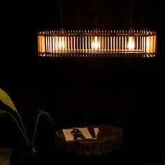 a dark room with a table and some lights in the corner, along with a plant