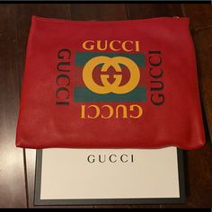 A Pouch Makes For A Great Travel Accessory. This Gucci Pouch Is Crafted From Red Leather And Styled With The Logo On The Front. The Zip Top Closure Opens. Gucci Designer Wallets With Logo, Designer Gucci Wallets With Logo, Designer Shopping Clutch Pouch, Designer Pouch Clutch For Shopping, Luxury Gucci Wallet With Logo, Designer Clutch Pouch For Shopping, Designer Clutch For Shopping, Designer Clutch Pouch, Gucci Red Designer Wallet