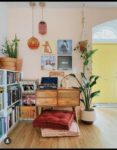 a living room filled with lots of furniture and bookshelves next to a yellow door