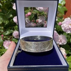 1960's Sterling silver heavy vintage bangle. This pretty sterling silver bangle has a flower and leaves engraving to the front, the reverse is plain.  A nice hinged bangle which could be stacked together with others or worn alone. The bangle has full clear and crisp sterling silver hallmarks dating it to Birmingham 1965-6. The fastener closes firmly and also has a safety chain.  The bangle has some small signs of wear such as surface scratches relative to its age.  Hallmarks  Assay Office-Anchor Engraved Bangle, Flower And Leaves, Eco Wedding, Vintage Hair Accessories, Sustainable Wedding, Sterling Silver Bangle Bracelets, Vintage Bangles, Floral Bracelet, Sterling Silver Bangle