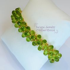 Italian made Green Peridot bead 18k yellow gold bracelet! Many 18k gold balls are scattered throughout the bracelet in between the peridot beads. A small white gold clasp completes the bracelet. There is one small 3 pointer diamond on the clasp. Total Weight: 54 grams Bracelet length: 7 inches Precious Metal: 18k yellow gold Precious stones: -Peridot Teardrops 9mmx5.2mm -White Round Diamonds: 0.03 carat, QTY 1 (on the clasp) Hallmark: 750 Faceted Yellow Gold Beaded Bracelets, Yellow Gold Faceted Beaded Bracelets, Elegant Peridot Round Beads Jewelry, Peridot Gemstone Beads Jewelry, Elegant Lime Green Faceted Jewelry, Yellow Gold Rondelle Gemstone Beaded Bracelets, Green Faceted Bead Bangle Jewelry, Green Faceted Beads Bangle, Elegant Lime Green Beaded Jewelry