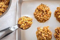 an oatmeal cookie is being scooped from a baking pan with spoons