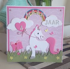 a pink card with a unicorn on the front and some clouds in the back that says jaar