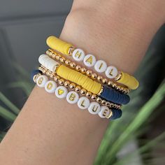 University of Michigan bracelets. Michigan Wolverines! Go Blue! Hail! Great birthday gift or graduation gift for a UofM Wolverines student, fan, grad, alumni, mom, the list is endless!  Customization available: If you would like the bracelet to say something else (Wolverines, UOFM, etc) please message me to order. Show your team pride with these University of Michigan heishi bead bracelets! Handcrafted with love and attention to detail, these bracelets feature vibrant maize and blue beads, representing the iconic colors of the Wolverines. Whether you're a proud alumni, a current student, or simply a fan of this esteemed institution, these bracelets are the perfect way to show off your love for the University of Michigan. Designed to be both fashionable and comfortable, our bracelets stretc College Football Bracelets, Blue Custom Name Friendship Bracelets, Customizable Blue Friendship Bracelets, Customized Blue Friendship Bracelets As Gift, Customizable Blue Name Bracelet For Friendship, Blue Custom Name Beaded Bracelets As Gift, Custom Name Blue Beaded Bracelets For Gift, Custom Name Blue Beaded Bracelets As Gift, Custom Name Blue Bracelets For Gift