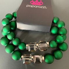 Paparazzi Shopaholic Showdown Showdown Green Bracelet Two Strands Of Oversized Emerald Green Beads Featuring A Subtly Shimmer, Silver Accents And Clear Gray Cubed Beads Stretch Around The Wrist, Creating Refined, Colorful Layers. Sold As A Set Of Two Individual Bracelets That Can Be Worn Together Or Separate. Check Out The Matching Necklace: Paparazzi Shopaholic Season Green Necklace Elegant Green Stretch Bracelet For Party, Green Bracelets For Christmas Party, Green Stretch Bracelet With Round Beads For Party, Green Round Beads Stretch Bracelet For Party, Green Beaded Stretch Bracelet For Party, Party Stretch Bracelet With Faceted Beads, Beach Wedding Red, Green Bracelet, Green Beads