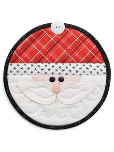 a christmas ornament with a santa clause on it's face and plaid background