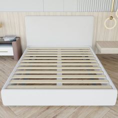 a white bed with wooden slats in a room that has wood floors and beige walls