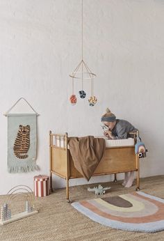 a small child is laying in his bed with toys on the floor next to him