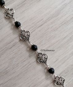 Bracelet with charms and black onyx beads. Black onyx is a stone of protection, it protects from the evil eye, it repels the presence of spirits who would try to influence you, it is very useful for mediums. It promotes a sense of responsibility and helps to maintain self-control by being more composed. Dimensions: 19 centimeters long and 1.3 centimeters wide If you want, I can add an extension chain. Materials used: zinc alloy and onyx (each natural stone being unique, they cannot be identical to the photography) This jewel will be delivered to you in a small organza pouch and sent by registered letter. To keep your jewelry in perfect condition, store them away from humidity and sunlight and avoid contact with water and perfume. Join me on: Instagram: https://www.instagram.com/darkmnesia Handmade Gothic Metal Bracelets, Elegant Black Rosary Bracelet With Round Beads, Handmade Silver Gothic Bracelets, Handmade Silver Gothic Bracelet, Nickel Free Black Metal Charm Bracelet, Handmade Onyx Black Bracelets, Handmade Gothic Silver Bracelets, Handmade Black Onyx Bracelets, Adjustable Nickel-free Black Charm Bracelet